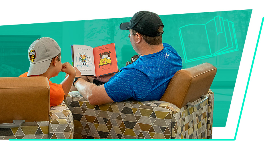 A man and young boy read a picture book together